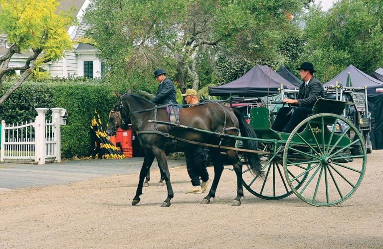 Cheltenham Road covered with gravel, with horse carriage and actors in early 20th-century costumes