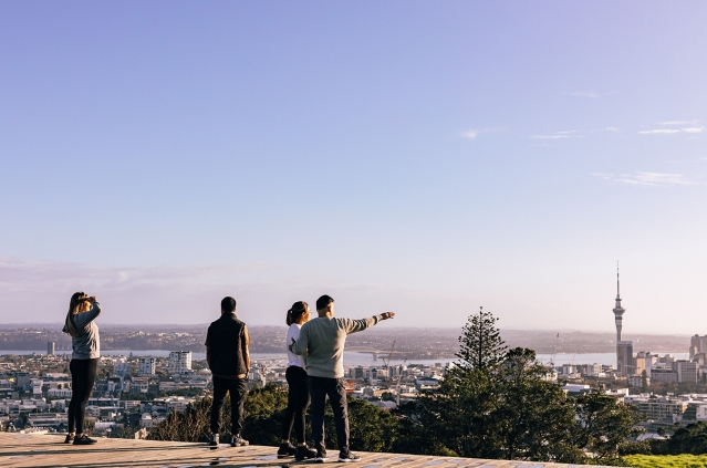 Group of people at the top of Mount Eden looking at Auckland skyline