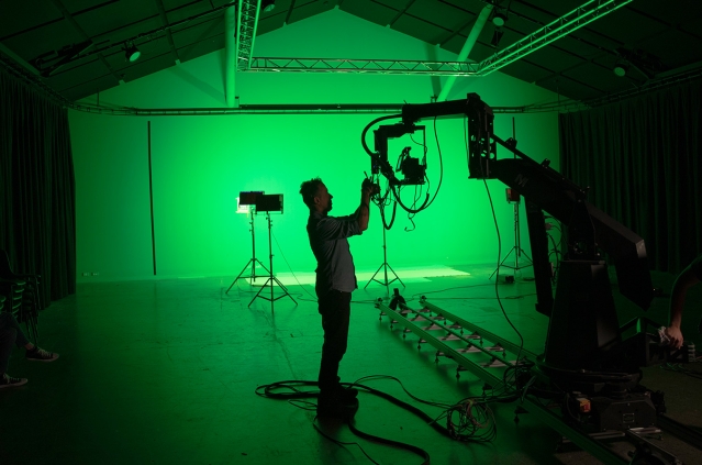 Silhouette of man standing in green lit production studio